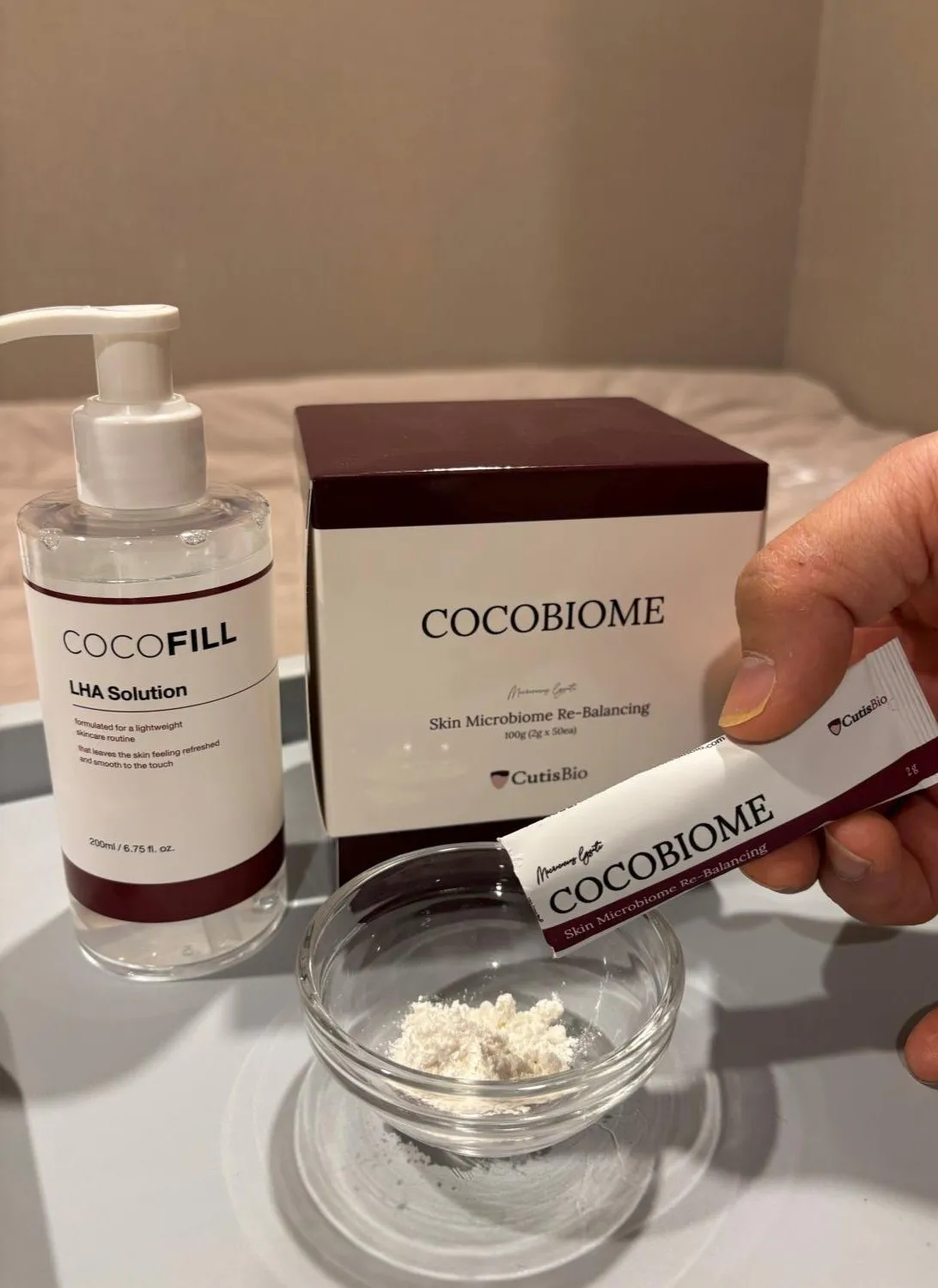 CocoBiome 상자와 분말, CocoFILL LHA solution 용기를 함께 보여주는 사진.